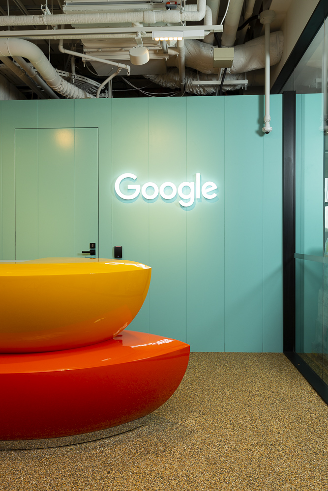 Interior fit out photography of Googles offices in Auckland, the google sign and colourful desk edge