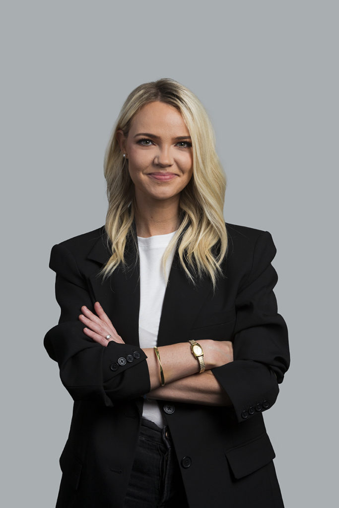 Professional Headshot Photo of woman in jacket on grey background