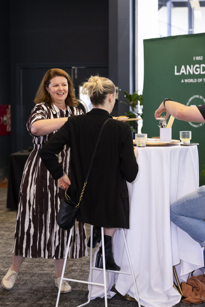 photograph of event host interacting with attendee 