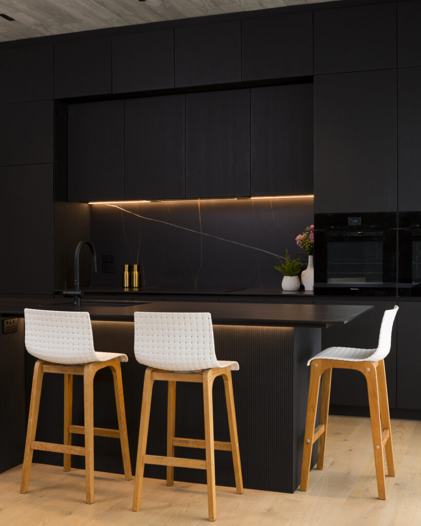 Dark kitchen with white stools for contrast. Interior photography in Ponsonby, Auckland