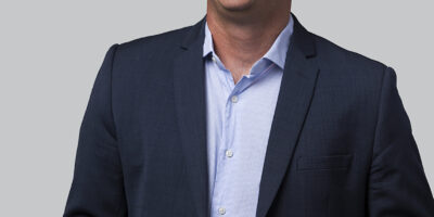 headshot of man in blue suit captured against a grey background in Auckland New Zealand