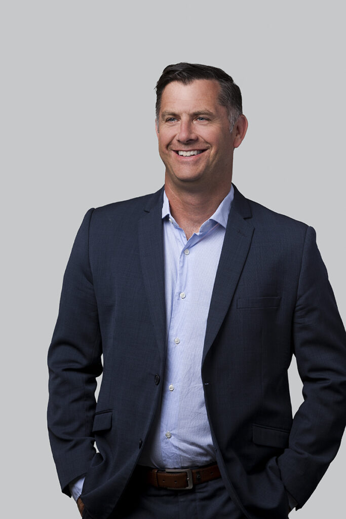 headshot of man in blue suit captured against a grey background in Auckland New Zealand