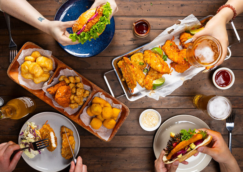 large table with food and hands grabbing the food, part of a professional food photography shoot in auckland new zealand